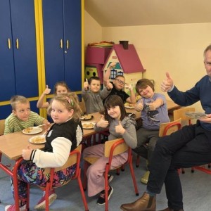 uczniowie i dyrektor jedzą